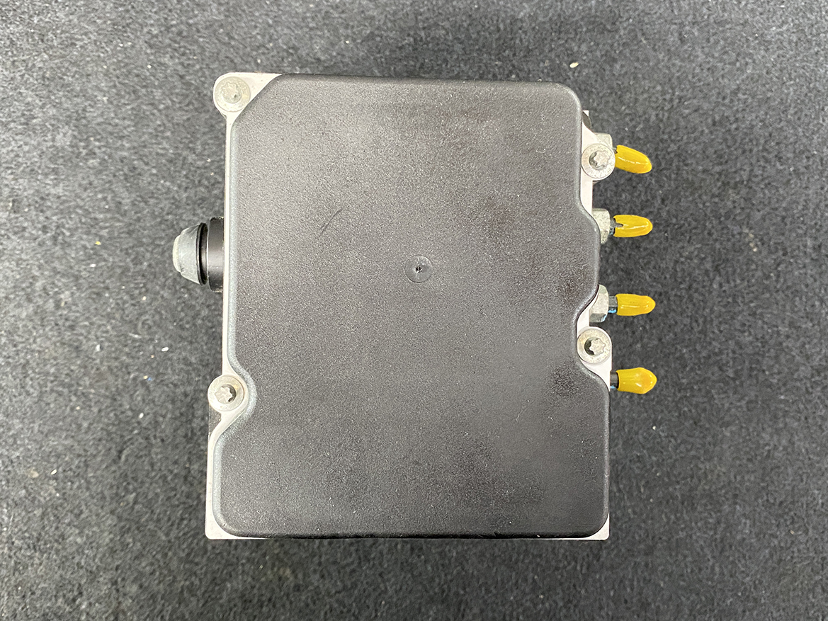 SUB-ACTR-27536SC050_14 Subaru Forester Genuine ABS Pump Module Actuator 27536SC050 » NZ9.95 » JDM-PARTS NZ » JDM-PARTS NZ Automotive engine control unit (ECU) with four yellow connector pins on the right and a black sensor/protrusion on the left, on a dark surface. Subaru Forester Genuine ABS Pump Module Actuator 27536SC050 » JDM-PARTS NZ