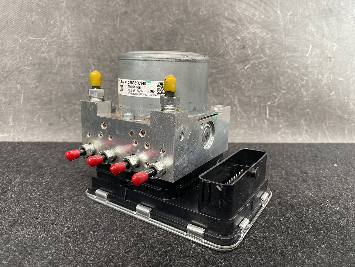 SUB-ACTR-FL140 _2 Subaru Impreza Genuine ABS Actuator Pump 27536FL140 » NZ9.95 » JDM-PARTS NZ » JDM-PARTS NZ Automotive ABS pump module with a metal hydraulic block, four red port fittings, and yellow cap tops on a black base baseplate. Subaru Impreza Genuine ABS Actuator Pump 27536FL140 » JDM-PARTS NZ