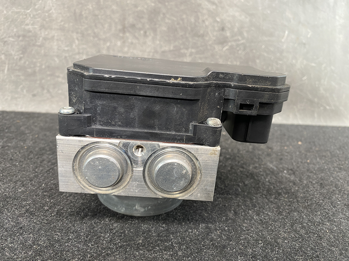 SUZ-ACTR-74PR _6 Suzuki Alto Genuine ABS Actuator Pump / 56110-74PR / 116040-40581 » NZ9.95 » JDM-PARTS NZ » JDM-PARTS NZ Automotive brake control module (ABS unit) with a black plastic top and a brushed aluminum face featuring two round metal caps. Suzuki Alto Genuine ABS Actuator Pump / 56110-74PR / 116040-40581 » JDM-PARTS NZ