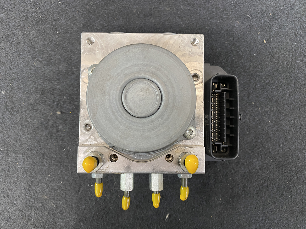 SUZ-ACTR-74PR _8 Suzuki Alto Genuine ABS Actuator Pump / 56110-74PR / 116040-40581 » NZ9.95 » JDM-PARTS NZ » JDM-PARTS NZ Automotive ABS brake pump module with a gray circular actuator, aluminum housing, and a multi-pin connector on the right side. Suzuki Alto Genuine ABS Actuator Pump / 56110-74PR / 116040-40581 » JDM-PARTS NZ