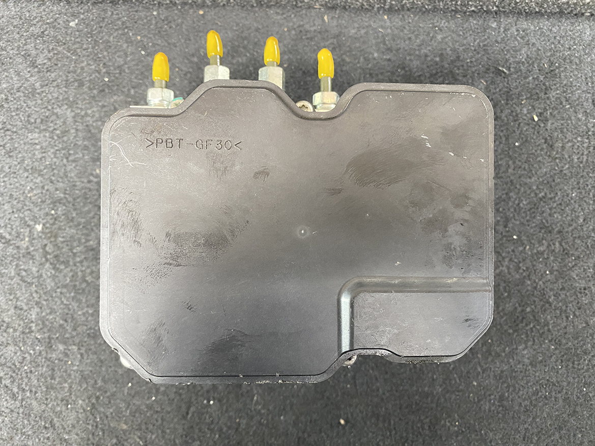 SUZ-ACTR-74PR _9 Suzuki Alto Genuine ABS Actuator Pump / 56110-74PR / 116040-40581 » NZ9.95 » JDM-PARTS NZ » JDM-PARTS NZ Black automotive electronic control module with four yellow-tipped connectors on top on a dark surface. Suzuki Alto Genuine ABS Actuator Pump / 56110-74PR / 116040-40581 » JDM-PARTS NZ