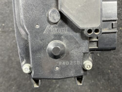 Close-up of a black Mikuni device housing with model 9402SB, showing screws and terminal holes.