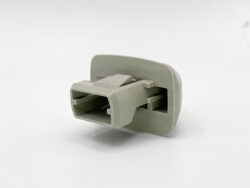 Two-slot gray plastic electrical connector housing with rectangular openings, mounted on a flat plate (informational component)