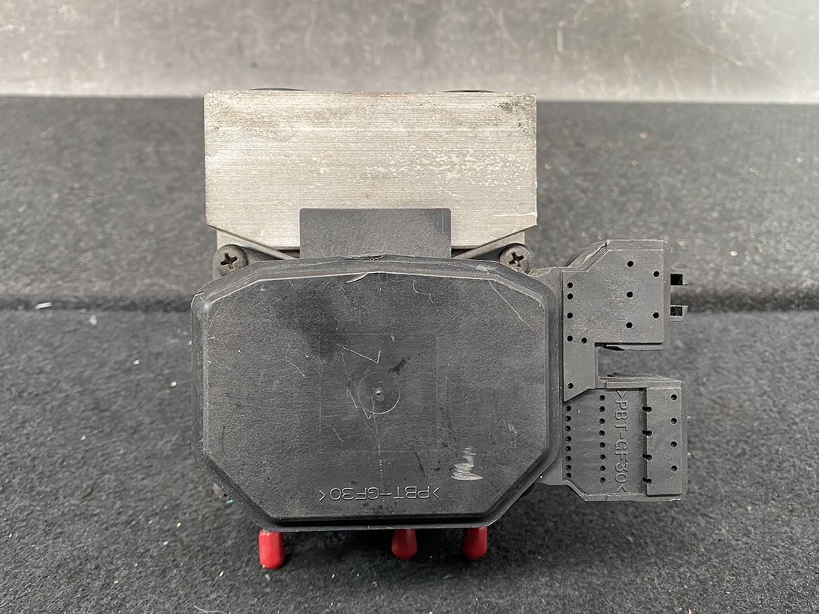TOY-ACTR-24060_10 Toyota Chaser Altezza Genuine ABS Actuator Pump 44510-24060 / 133000-5050 » NZ9.95 » JDM-PARTS NZ » JDM-PARTS NZ Electrical control/actuator module: black octagonal housing with a metal mounting block on top and two multi-pin connectors on the right side, dusty and worn. Toyota Chaser Altezza Genuine ABS Actuator Pump 44510-24060 / 133000-5050 » JDM-PARTS NZ