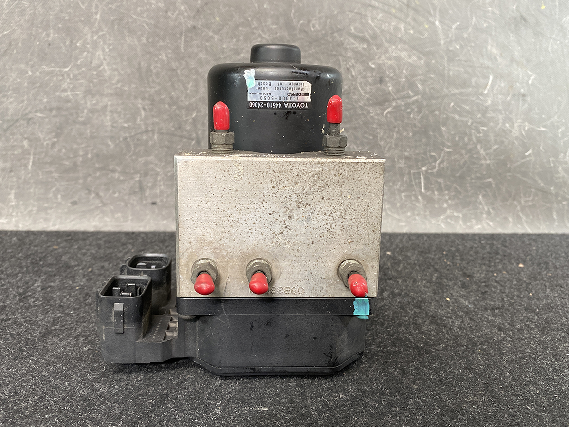 TOY-ACTR-24060_5 Toyota Chaser Altezza Genuine ABS Actuator Pump 44510-24060 / 133000-5050 » NZ9.95 » JDM-PARTS NZ » JDM-PARTS NZ Metal hydraulic control unit with four red-tipped ports and a black connector, likely an automotive brake modulator component. Toyota Chaser Altezza Genuine ABS Actuator Pump 44510-24060 / 133000-5050 » JDM-PARTS NZ