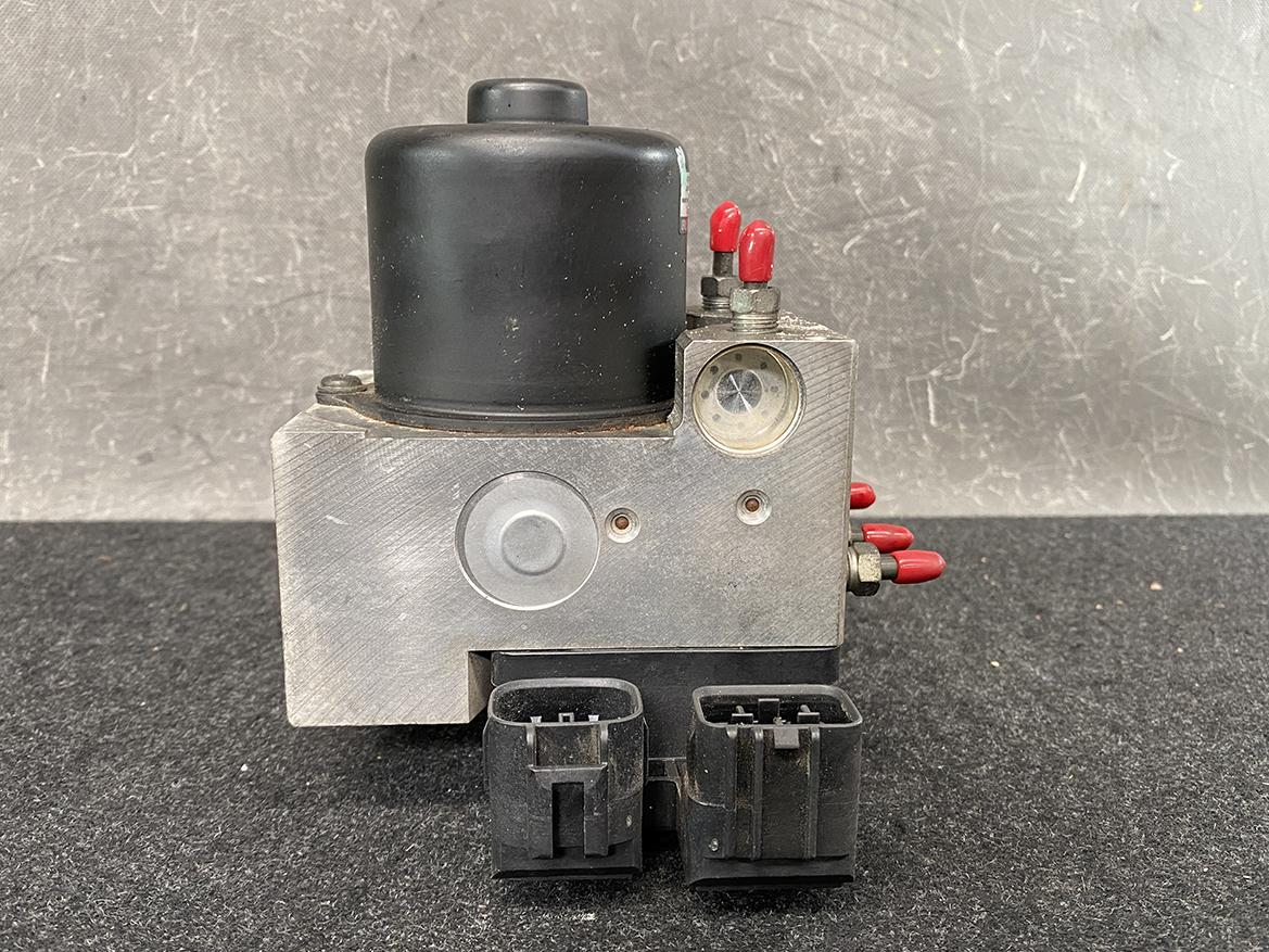 TOY-ACTR-24060_8 Toyota Chaser Altezza Genuine ABS Actuator Pump 44510-24060 / 133000-5050 » NZ9.95 » JDM-PARTS NZ » JDM-PARTS NZ Automotive ABS brake pump module with a black cylindrical top, metal housing, red electrical terminals, and two large plug connectors at the base. Toyota Chaser Altezza Genuine ABS Actuator Pump 44510-24060 / 133000-5050 » JDM-PARTS NZ