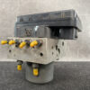 Automotive ABS hydraulic control module with yellow protective caps on ports and a dark control unit on top. Honda Genuine ABS Actuator Pump T5BJ0 / 57110-T5B-J02 » JDM-PARTS NZ