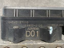 Close-up of a dusty Advics D01 component with part numbers 44540-37110 and 133800-2120, marked Made in Japan.