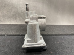 Benchtop industrial power tool with a vertical spindle and mounting base, used for grinding or shaping metal.