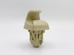 Beige plastic chair-like component mounted on a complex base, isolated on a white background.