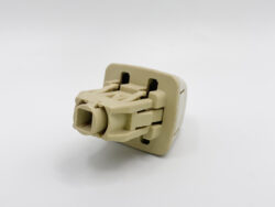 Beige plastic electrical connector plug with locking tabs on a white background.