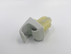 Small gray plastic clip with a curved inner cavity attached to a yellow translucent housing piece