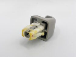 Gray automotive electrical connector plug with yellowed inner contact housing.