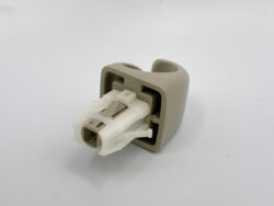 Beige plastic housing with a white modular electrical connector protruding from it, viewed in close-up.