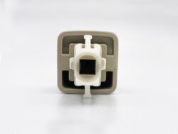 Close-up of a beige square electrical outlet insert with a white central connector and a square black opening in the middle.