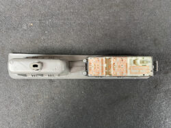 Disassembled car key fob showing the orange circuit board and internal hardware on a gray shell.