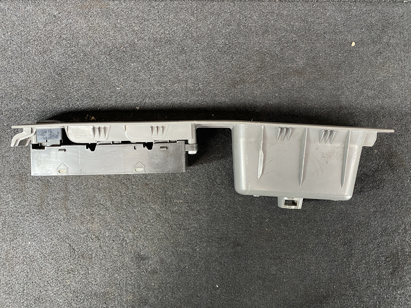 B487_9 NISSAN CUBE Z11 Genuine Master Power Window Switch 80960 3U000 » NZ.95 » JDM-PARTS NZ » JDM-PARTS NZ Grey plastic automotive interior trim panel with mounting clips and an attached electrical module, shown on a dark surface. NISSAN CUBE Z11 Genuine Master Power Window Switch 80960 3U000 » JDM-PARTS NZ