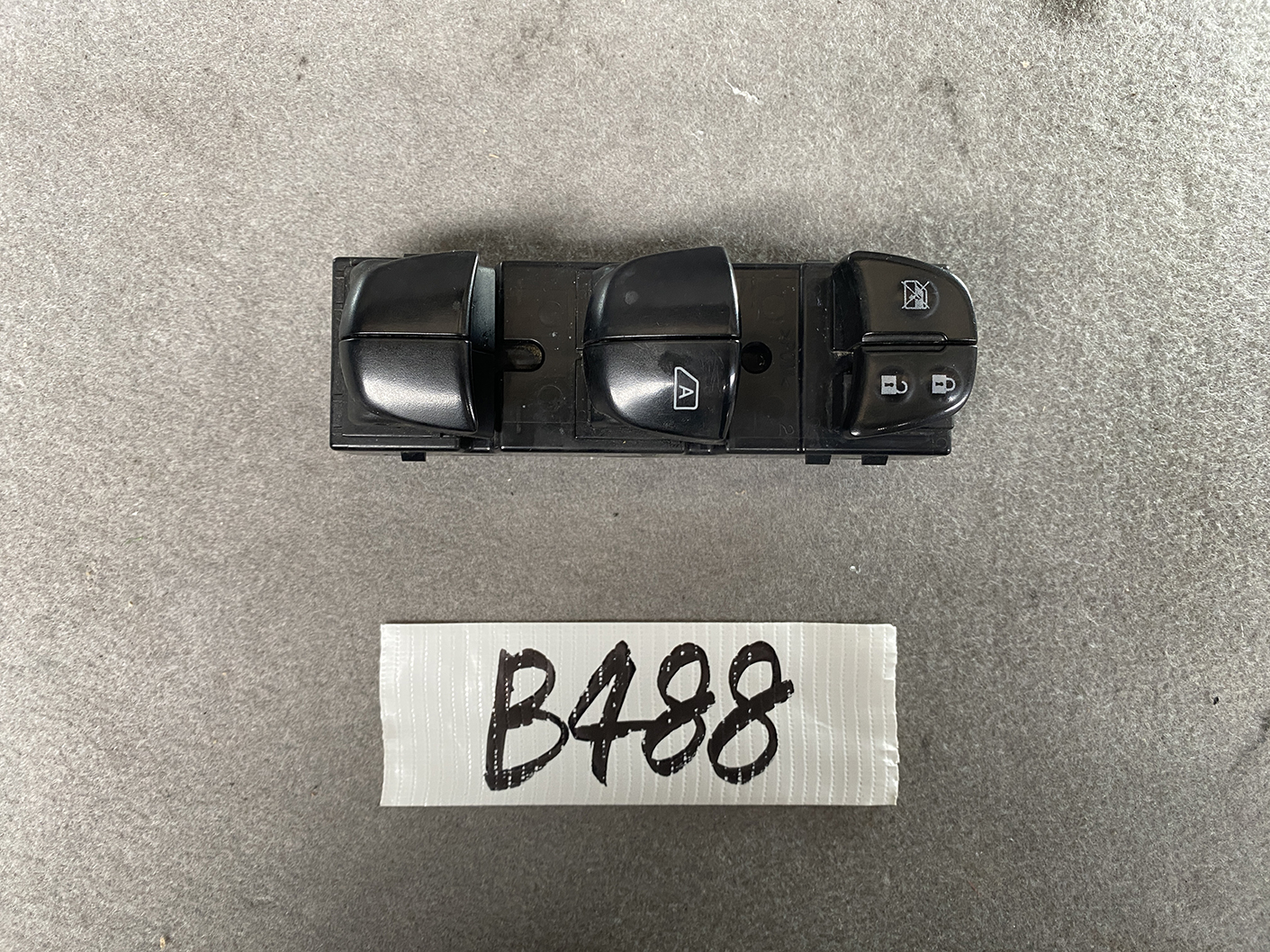 B488_2 NISSAN SERENA SUZUKI LANDY C26 Genuine Master Power Window Switch 25401 1VA7A » NZ.95 » JDM-PARTS NZ » JDM-PARTS NZ Black automotive power window switch panel with four rocker switches, including window lock icons, placed above a white card labeled B488. NISSAN SERENA SUZUKI LANDY C26 Genuine Master Power Window Switch 25401 1VA7A » JDM-PARTS NZ