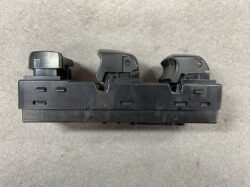 Three-lever automotive control switch module mounted on a black plastic housing.
