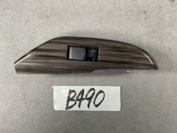 Woodgrain finish automotive interior trim piece with a single black rectangular switch embedded in the center.