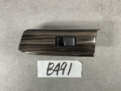 Woodgrain car interior panel with a single black window switch in the center.