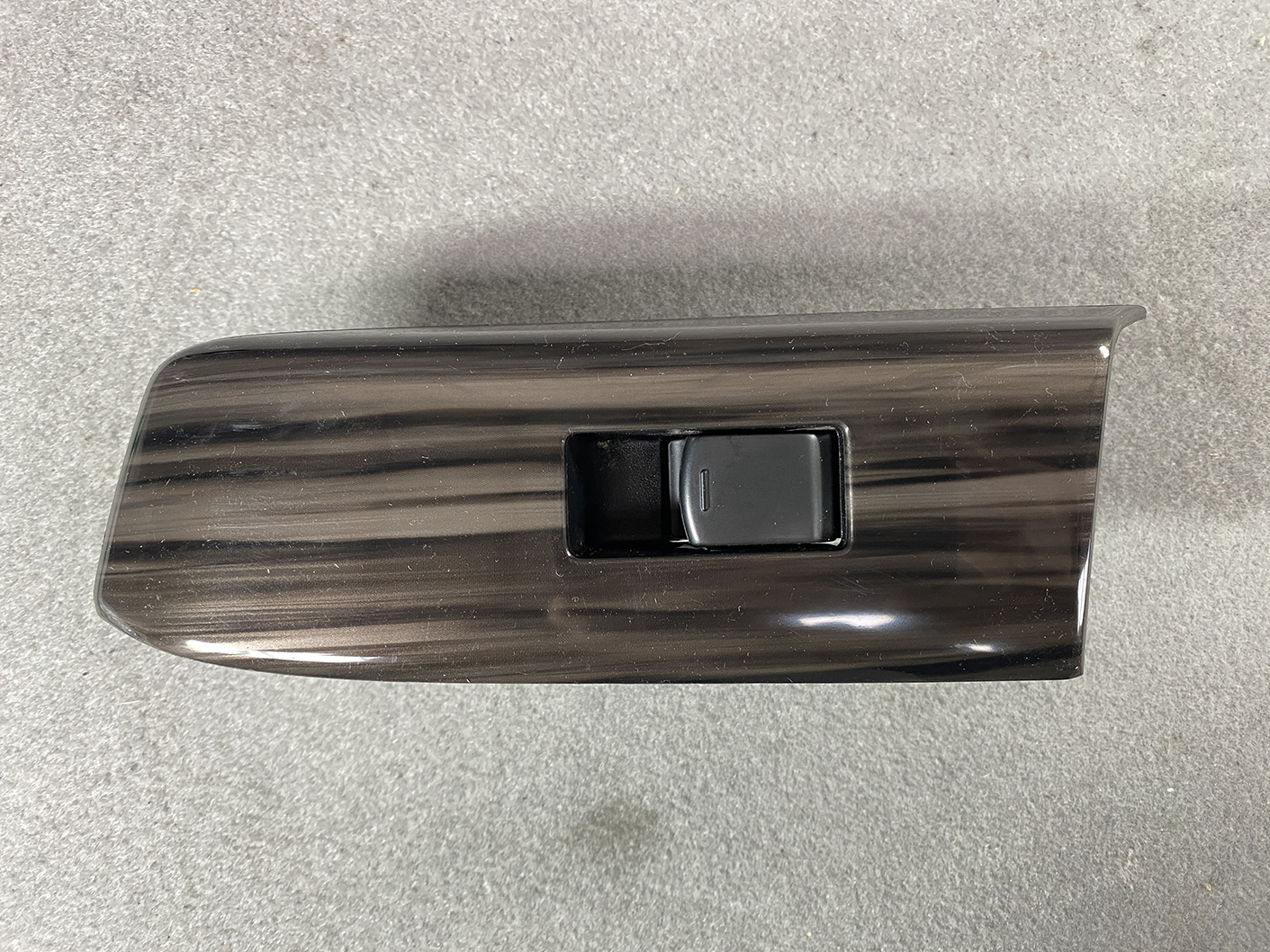 B491_3 NISSAN ELGRAND E52 Genuine Front Left Power Window Switch 25411 JD05A » NZ.95 » JDM-PARTS NZ » JDM-PARTS NZ Glossy dark woodgrain car door panel with a black power window switch in a recessed pocket. NISSAN ELGRAND E52 Genuine Front Left Power Window Switch 25411 JD05A » JDM-PARTS NZ