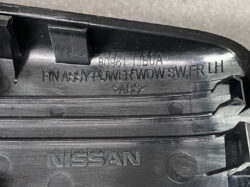 Nissan front left power window switch assembly in black plastic with part numbers and ABS marking on it, photographed up close.