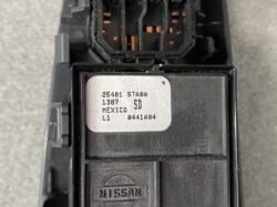 Close-up of a Nissan electrical module with a white label showing part numbers and 'MEXICO' text, Nissan logo below.