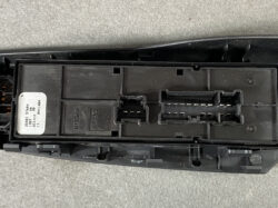 Close-up of a black automotive control module with two multi-pin connector sockets and a Nissan label on the left side librarian area.
