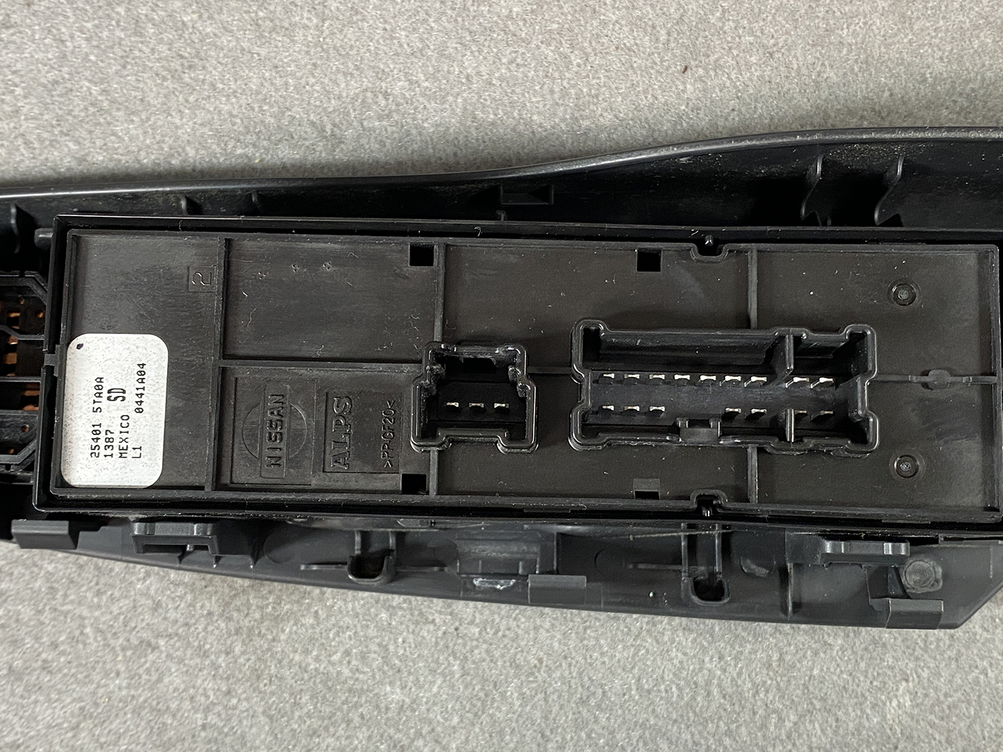 B492_7 NISSAN SERENA SUZUKI LANDY C27 Master Power Window Switch 25401 5TA0A » NZ1.95 » JDM-PARTS NZ » JDM-PARTS NZ Close-up of a black automotive control module with two multi-pin connector sockets and a Nissan label on the left side librarian area. NISSAN SERENA SUZUKI LANDY C27 Master Power Window Switch 25401 5TA0A » JDM-PARTS NZ