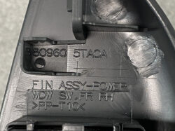 Close-up of a molded plastic automotive part with part numbers and 'FIN ASSY-POWER' engraving.