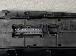 Close-up of a black plastic connector block with two multi-pin sockets and metal contacts in the housing.