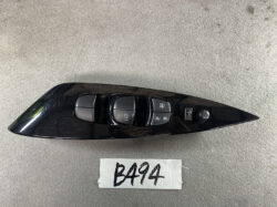Black car door panel with power window controls and mirror adjustment knob.