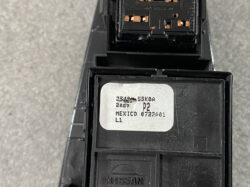 Close-up of a Nissan automotive control module with a white label showing part codes and 'Mexico' origin.