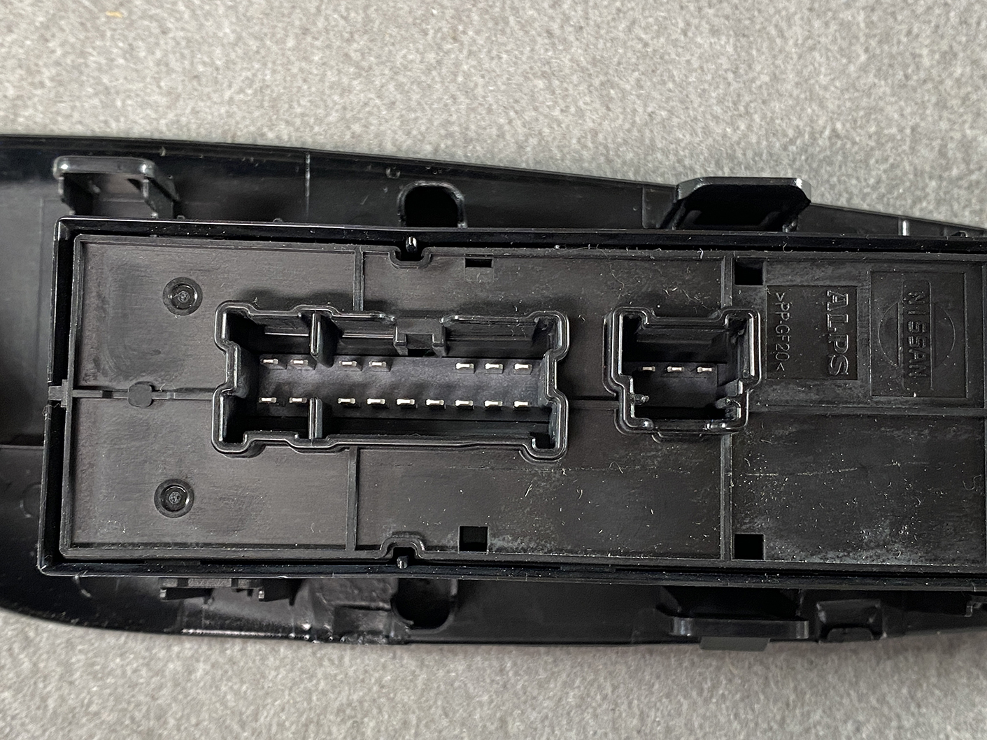 B494_6 NISSAN NOTE E11 Genuine Master Power Window Switch 25401 5SK0A » NZ.95 » JDM-PARTS NZ » JDM-PARTS NZ Black automotive electrical connector housing with two multi-pin receptacles and latch tabs, showing exposed metal pins inside. NISSAN NOTE E11 Genuine Master Power Window Switch 25401 5SK0A » JDM-PARTS NZ