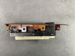 Side view of a brown plastic car window switch assembly with a black base and beige mounting portion. Ready to install in a vehicle door.