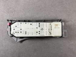 Backside of a Toyota instrument cluster electronics module with a light gray PCB and pink release clip at left.