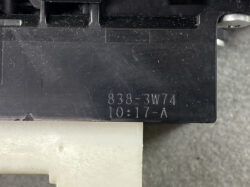 Close-up of a black plastic part showing embossed code: 838-3W74 10:17-A, likely a part ID and timestamp.
