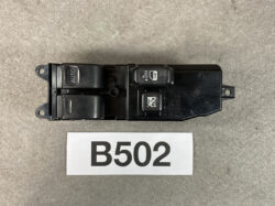 Car power window switch assembly with two window buttons and a window lock button, labeled B502 on a dark base.