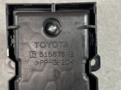 Close-up of a black Toyota automotive plastic component with a central screw and molded text: TOYOTA R 515676 B >PP-GF20