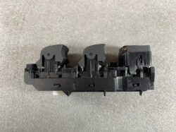 Black plastic double switch assembly with two curved actuators, likely a vehicle control module