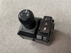 Close-up of a car multi-function stalk with a knurled dial marked L and R (likely a turn signal control) and a nearby vertical switch labeled A on a black plastic assembly