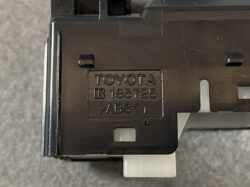 Close-up of a black Toyota plastic part stamped with 'TOYOTA IR 183725 >ABS