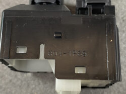 Close-up of a black electrical module with the stamp '804-1P69' and small square openings on its surface.