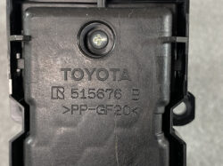 Close-up of a black Toyota automotive plastic part with a central screw and molded markings: TOYOTA R515676 B >PP-GF20