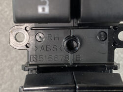 Close-up of a black ABS module with the engraving 'RH ABS R515678 B' on it.