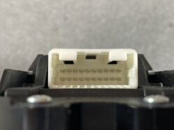 White 16‑pin electrical connector receptacle mounted in a black housing, viewed from the front.