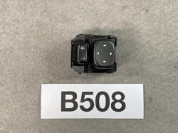 Car power mirror control switch with L/R selector and four-way directional pad for adjusting side mirrors.