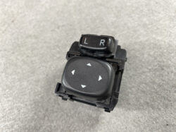 Car mirror adjustment switch: 'L' and 'R' selector with a four‑way directional pad below for steering mirror positioning