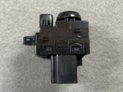 Close-up of a black plastic electrical housing with a round knob on top and a small side lever, marked with NilesABS on the front.